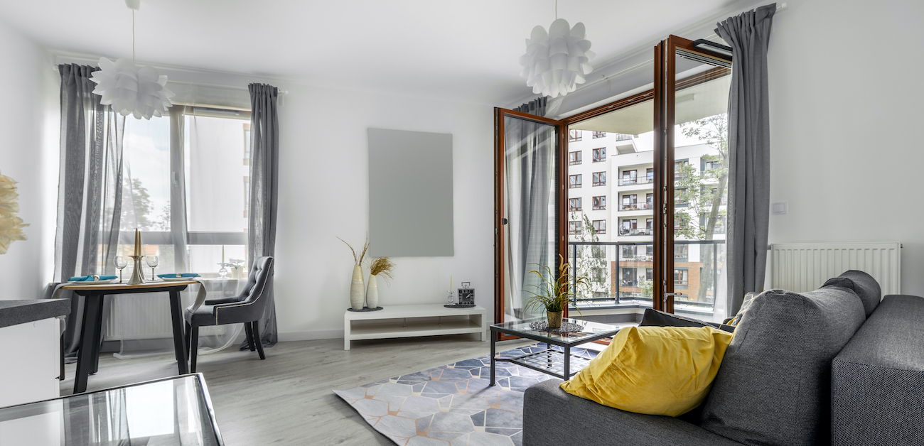 A bright, spotless living room in a Charlotte home after a residential clean — sofa, dining area, and balcony doors gleaming